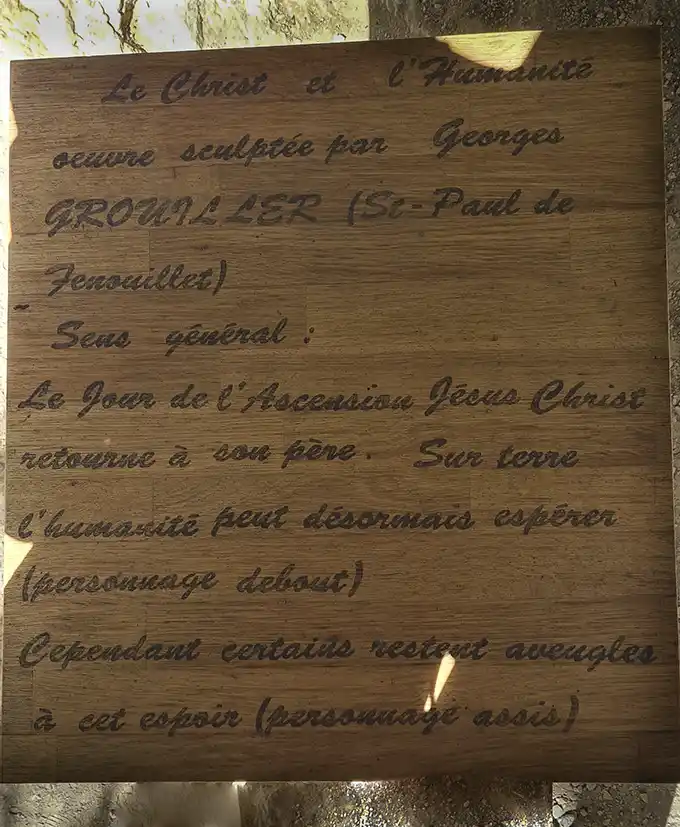 Cartel de madera escrito en francés de una obra llamada Jesús y la Humanidad